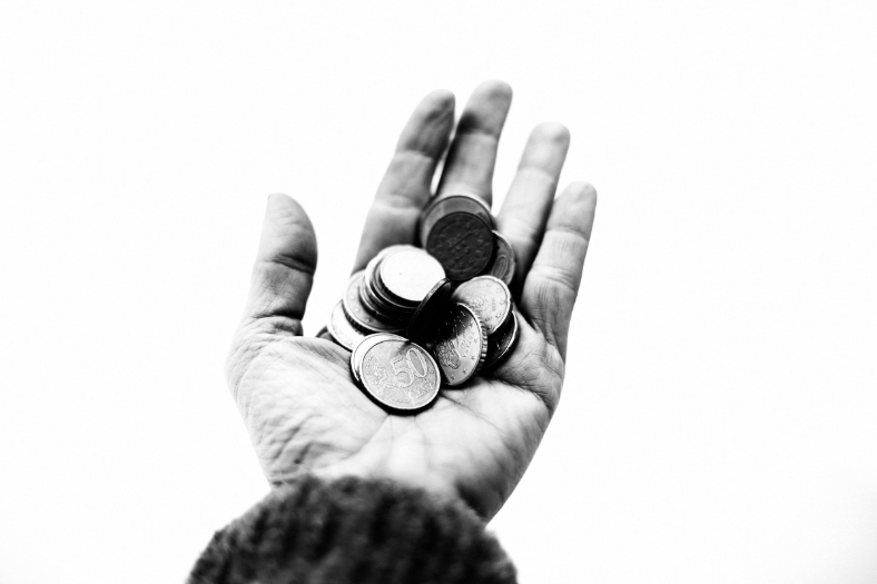 Person holding coins in their hand.